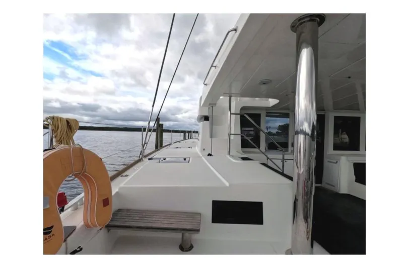 Slide: The Image of 2021 Lagoon 52 F catamaran deck view with life preserver and railing. - 23