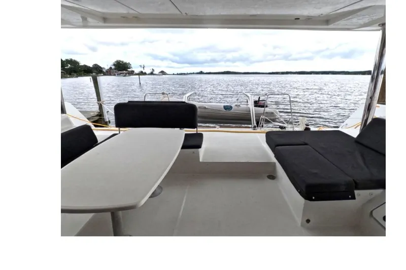 Slide: The Image of Lagoon 52 F 2021 yacht deck with seating, overlooking serene waters. - 3