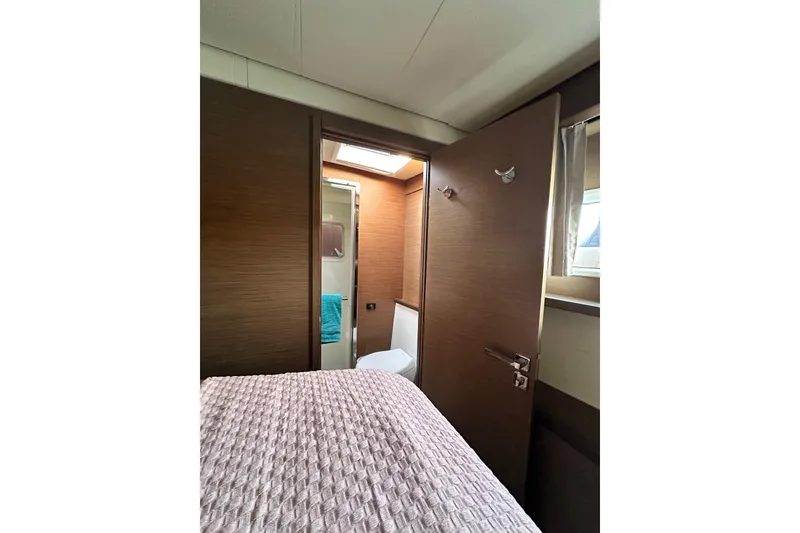 Slide: The Image of Interior of 2021 Lagoon 52 F yacht cabin with bed and bathroom view. - 35