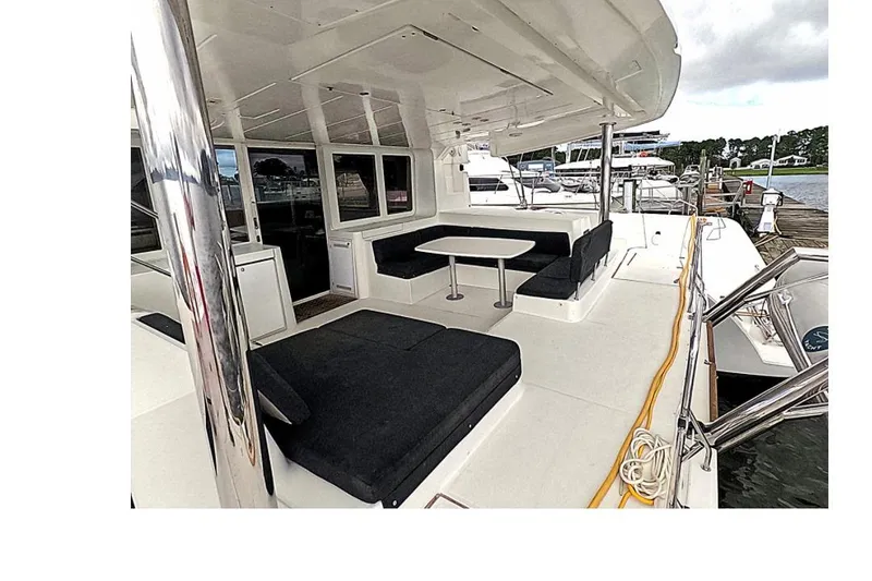 Slide: The Image of 2021 Lagoon 52 F yacht deck with seating and table, docked at marina. - 5