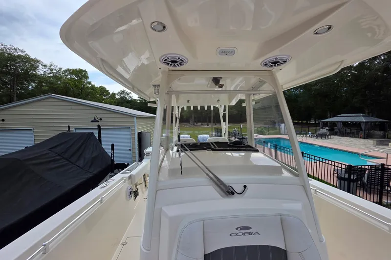 Slide: The Image of 2022 Cobia 320 Center Console boat near a pool and garage. - 11
