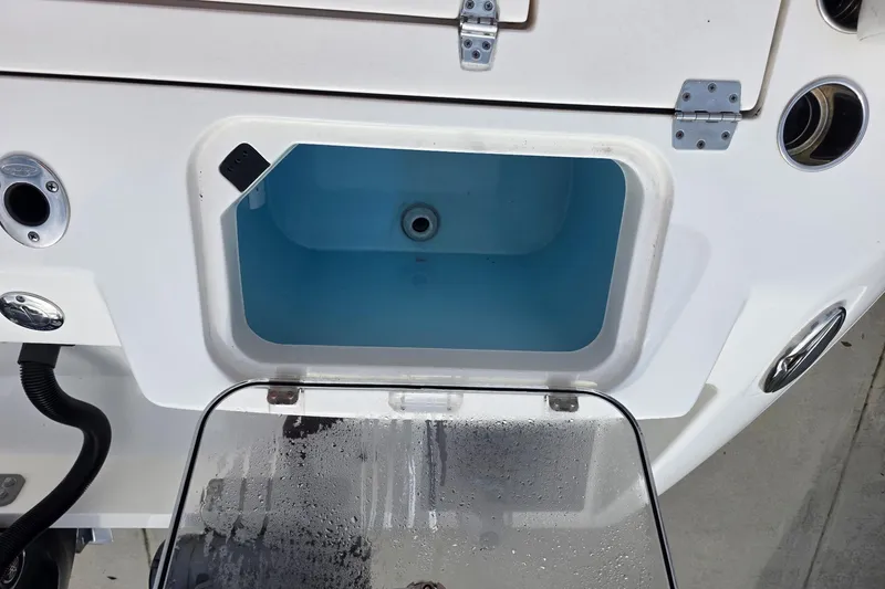 Slide: The Image of Livewell on 2022 Cobia 320 Center Console boat, featuring open lid and drainage system. - 19
