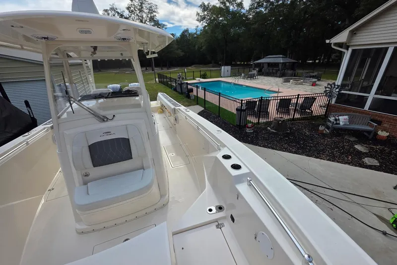 Slide: The Image of 2022 Cobia 320 Center Console boat near a backyard pool and patio area. - 21