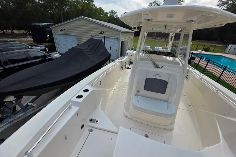 Slide: The Image of 2022 Cobia 320 Center Console boat in driveway near garage and pool. - 22