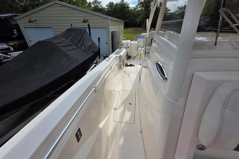 Slide: The Image of 2022 Cobia 320 Center Console boat docked near a storage shed. - 24