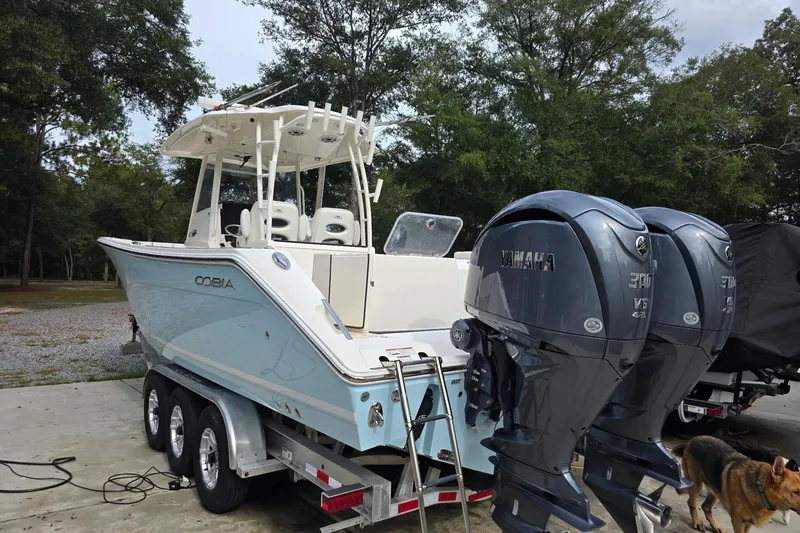 Slide: The Image of 2022 Cobia 320 Center Console boat with dual Yamaha engines on a trailer. - 3