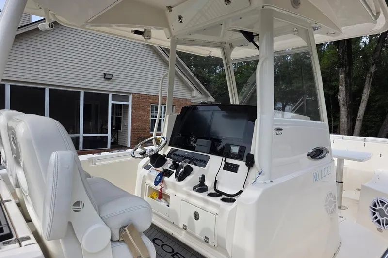 Slide: The Image of 2022 Cobia 320 Center Console boat interior with modern navigation equipment and white seating. - 6
