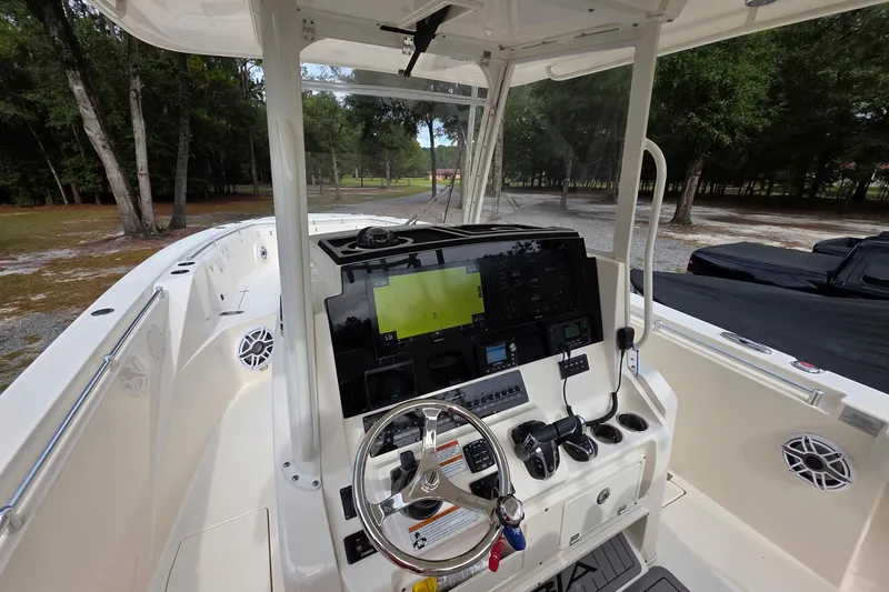 Slide: The Image of 2022 Cobia 320 Center Console boat interior with advanced navigation system and steering wheel. - 7