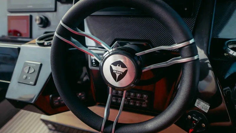 Slide: The Image of Steering wheel of 2023 Skipper-BSK 42 boat, featuring modern dashboard controls. - 11