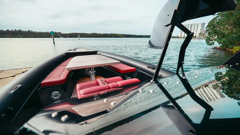 Slide: The Image of 2023 Skipper-BSK 42 boat with red seating and table on calm water. - 27