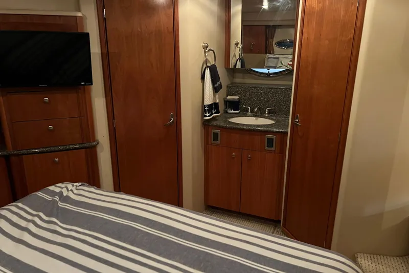 Slide: The Image of 2004 Meridian 408 Motoryacht interior with wood cabinetry, sink, and striped bedding. - 18