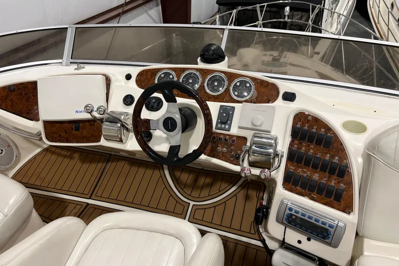 Slide: The Image of 2004 Meridian 408 Motoryacht helm with wood accents and modern controls. - 8