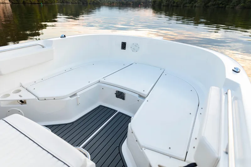Slide: The Image of 2026 Bayliner Trophy T22CC boat interior with seating, on calm water. - 14
