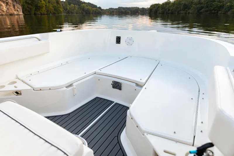 Slide: The Image of 2026 Bayliner Trophy T22CC boat interior with seating, on a calm river. - 15