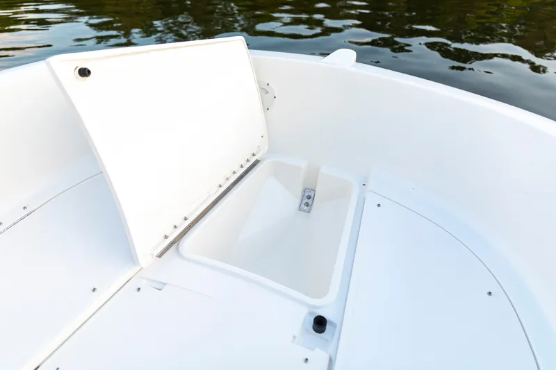 Slide: The Image of 2026 Bayliner Trophy T22CC boat storage compartment open on calm water. - 20
