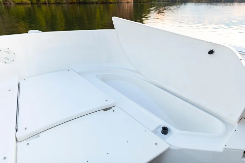 Slide: The Image of 2026 Bayliner Trophy T22CC boat storage compartment by the water. - 21