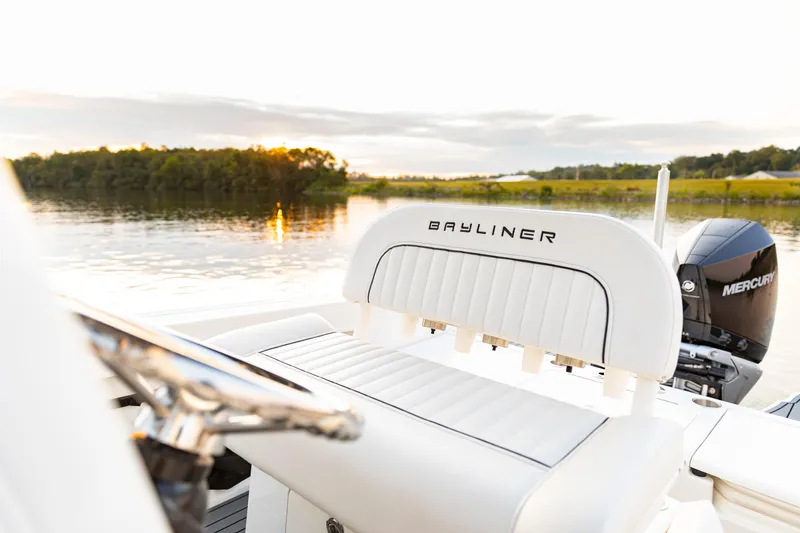 Slide: The Image of 2026 Bayliner Trophy T22CC boat interior with Mercury engine, serene lake view at sunset. - 23