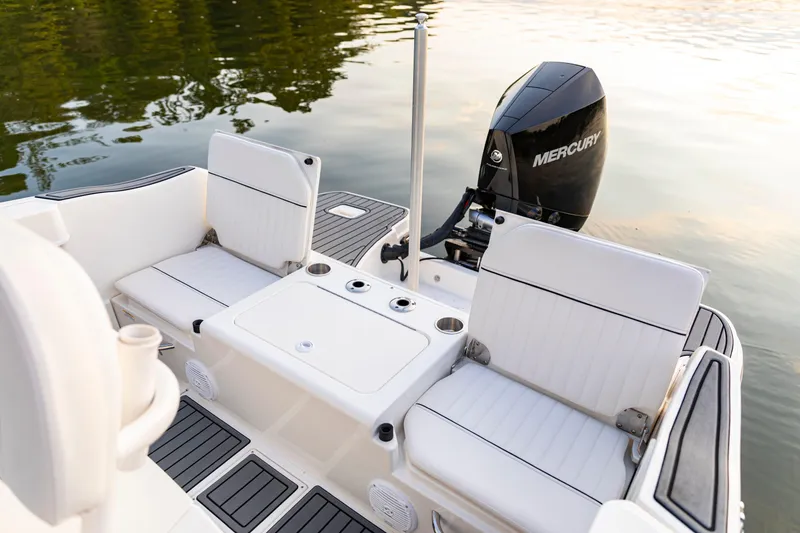 Slide: The Image of 2026 Bayliner Trophy T22CC boat interior with Mercury engine, featuring white seating and cup holders. - 36