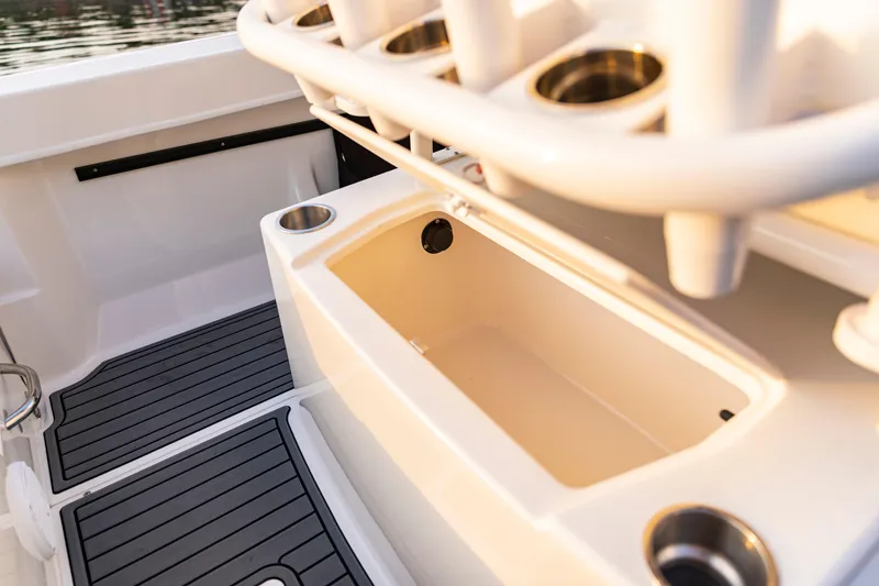 Slide: The Image of 2026 Bayliner Trophy T22CC boat interior with rod holders and storage compartment. - 39