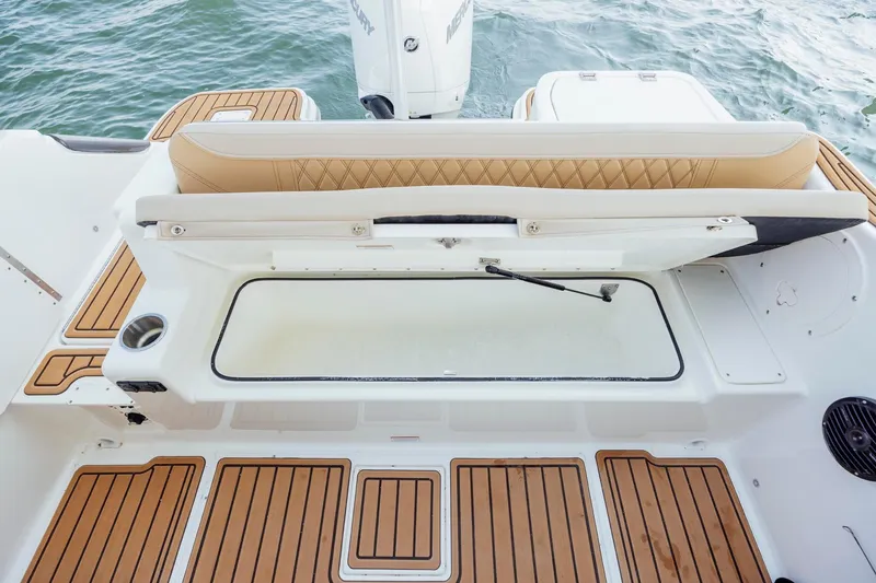Slide: The Image of 2026 Bayliner Trophy T22SC boat interior with cushioned seating and storage compartment. - 10