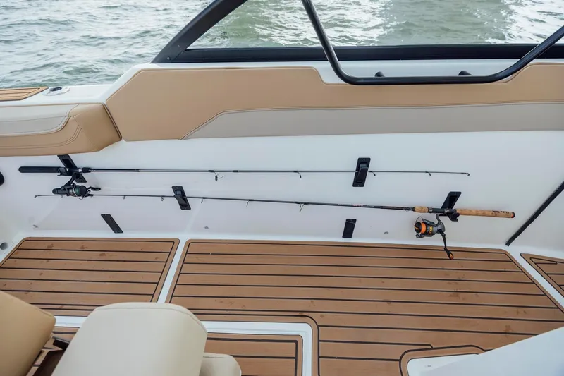 Slide: The Image of 2026 Bayliner Trophy T22SC boat interior with fishing rod holders and teak flooring. - 17