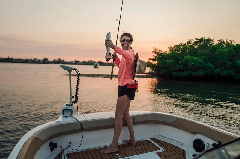 Slide: The Image of Woman fishing on 2026 Bayliner Trophy T22SC boat at sunset. - 23