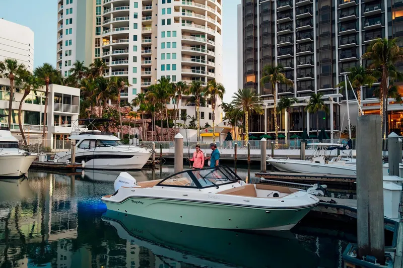 Slide: The Image of 2026 Bayliner Trophy T22SC boat docked in a marina with modern buildings in the background. - 26