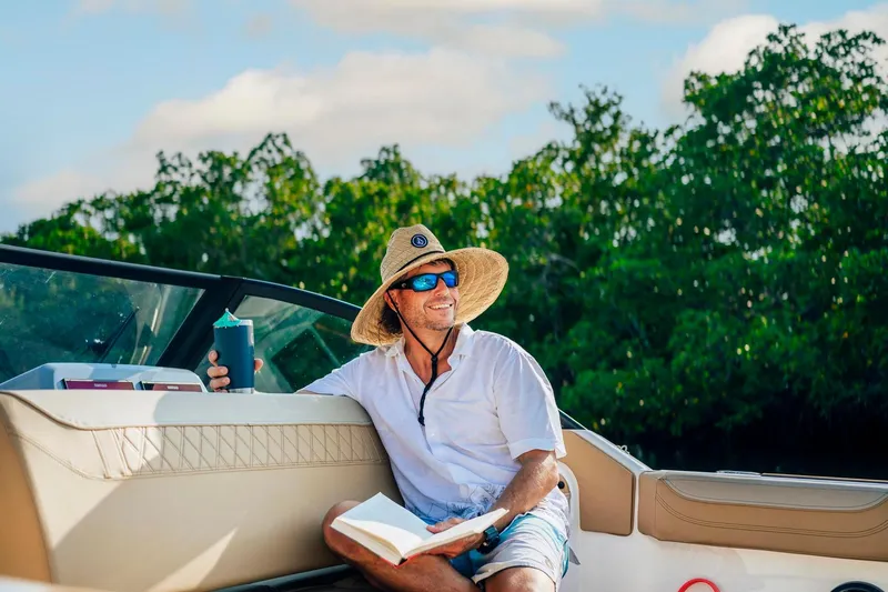 Slide: The Image of Man relaxing on a 2026 Bayliner Trophy T22SC boat, enjoying a sunny day. - 36