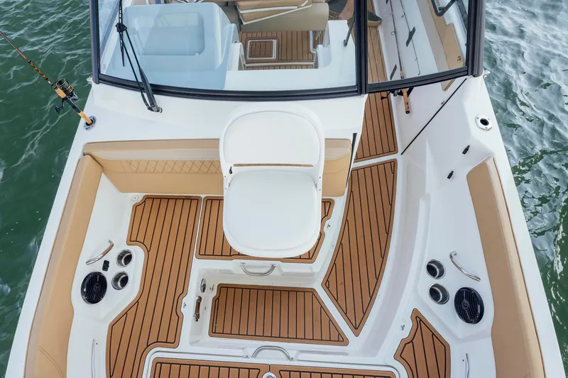 Slide: The Image of 2026 Bayliner Trophy T22SC boat deck with seating and wood finish, on water. - 5