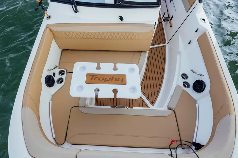 Slide: The Image of 2026 Bayliner Trophy T22SC boat interior with tan seating and table on water. - 6