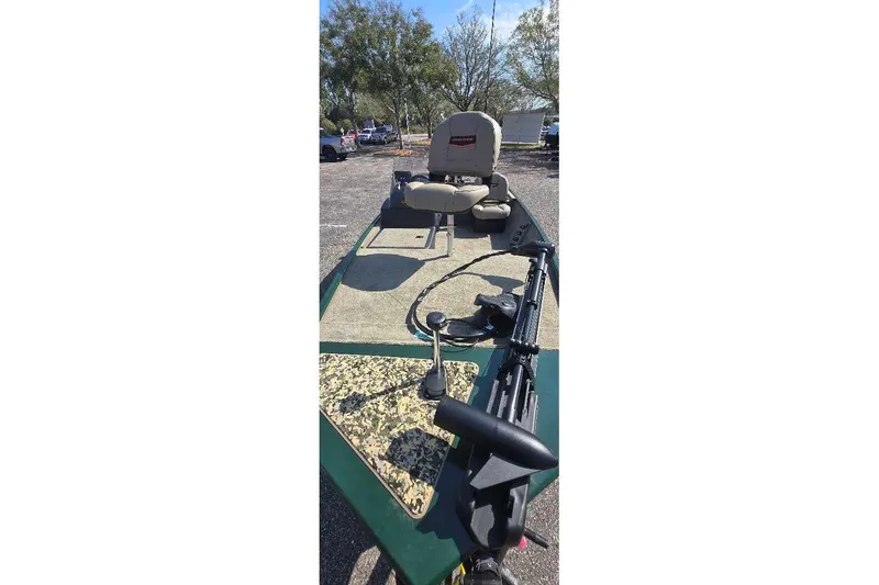 Slide: The Image of 2026 Tracker Bass Tracker Classic Limited boat with seating and trolling motor in a parking lot. - 2