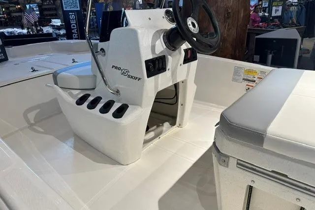 Slide: The Image of 2026 Mako Pro Skiff 15 CC boat interior with steering console and seating. - 6