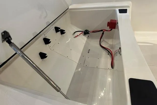 Slide: The Image of Open storage compartment of 2026 Mako Pro Skiff 15 CC boat, showing wiring and interior details. - 10