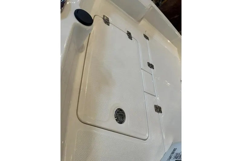 Slide: The Image of 2026 Mako Pro Skiff 15 CC boat hatch with secure latches and textured surface. - 11