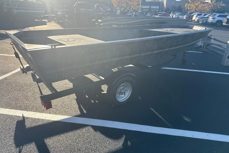 Slide: The Image of 2026 Tracker Grizzly 1648 Utility boat on trailer in parking lot. - 2