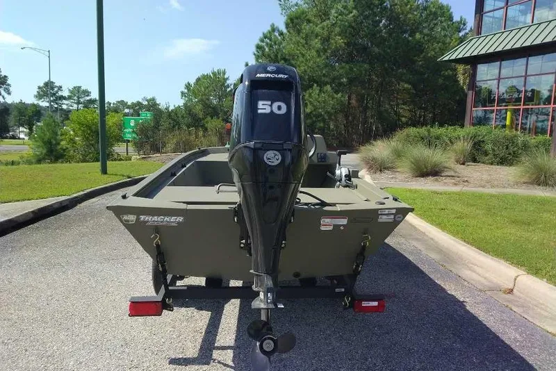 Slide: The Image of 2026 Tracker Grizzly 1648 SC boat with Mercury 50 engine, parked outdoors. - 2