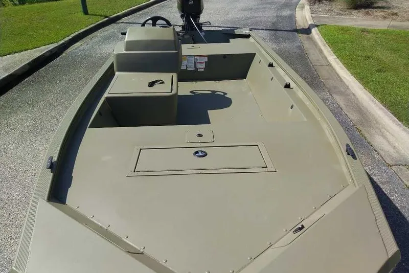 Slide: The Image of 2026 Tracker Grizzly 1648 SC boat on a paved road, showcasing its spacious deck. - 3