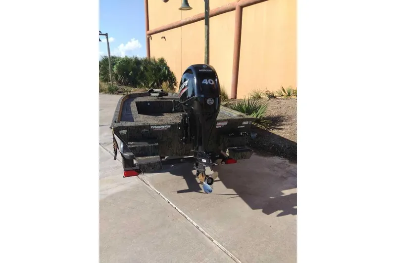 Slide: The Image of 2026 Tracker Grizzly 1654 T Sportsman boat with Mercury 40 HP engine, parked outdoors. - 42