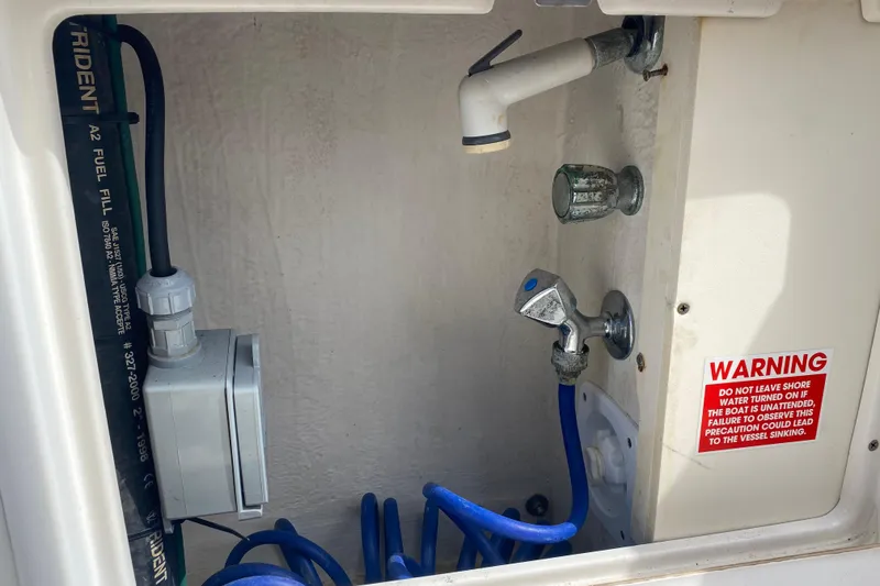Slide: The Image of Boat utility compartment with hoses and warning label, Riviera 4000, year 2000. - 13