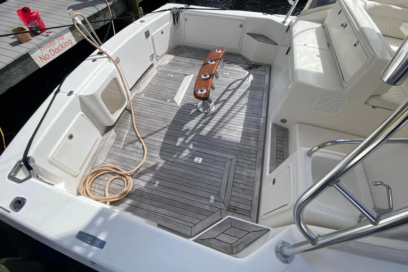 Slide: The Image of Spacious deck of 2000 Riviera 4000 boat with wooden flooring and seating. - 2