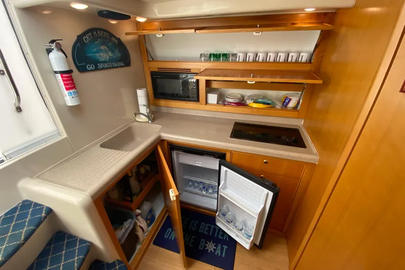Slide: The Image of Compact kitchen in 2000 Riviera 4000 boat with sink, fridge, and microwave. - 42