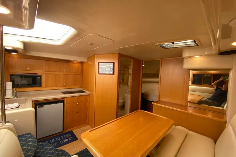 Slide: The Image of Interior of 2000 Riviera 4000 yacht with kitchen, dining area, and cozy seating. - 46