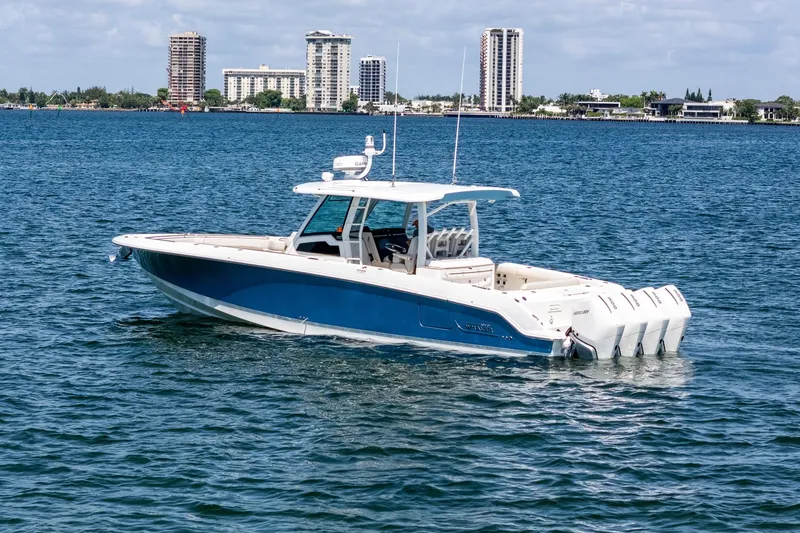 Slide: The Image of 2022 Boston Whaler 380 Outrage boat on water with city skyline in background. - 10