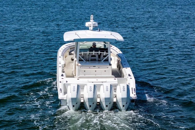 Slide: The Image of 2022 Boston Whaler 380 Outrage cruising on open water, rear view. - 13