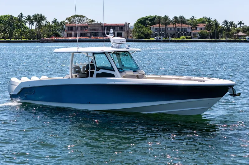 Slide: The Image of 2022 Boston Whaler 380 Outrage boat cruising on a sunny day near luxury waterfront homes. - 17