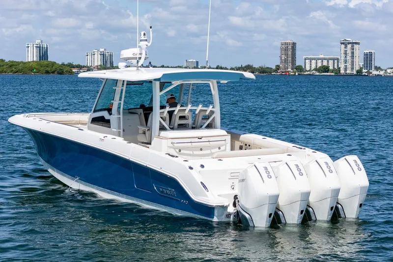 Slide: The Image of 2022 Boston Whaler 380 Outrage boat with four engines on a sunny day. - 22