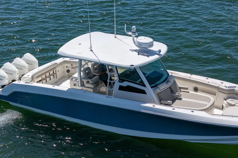 Slide: The Image of 2022 Boston Whaler 380 Outrage cruising on open water, showcasing sleek design and powerful engines. - 35