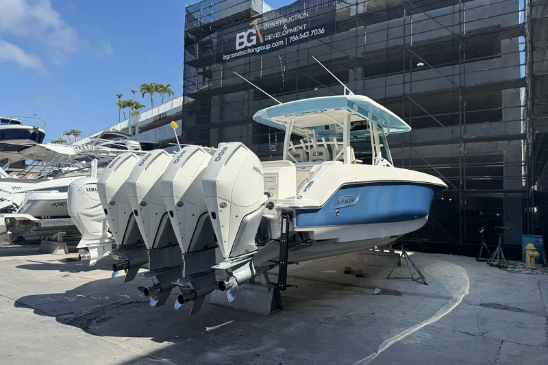 Slide: The Image of 2022 Boston Whaler 380 Outrage boat with four powerful outboard engines in a marina setting. - 36