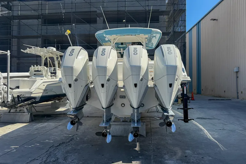 Slide: The Image of 2022 Boston Whaler 380 Outrage with four powerful outboard engines, docked in a marina. - 37