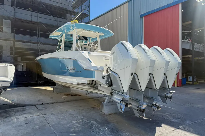 Slide: The Image of 2022 Boston Whaler 380 Outrage with four outboard engines, docked at a marina. - 38